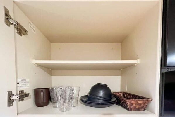A kitchen cabinet with a hanging shelf, a coffee maker, and a basket of bread. - ION Shibuya-honmachi (Tokyo)
