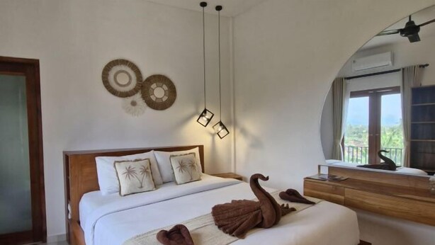Une chambre d’hôtel avec un lit, une commode en bois, un miroir et une fenêtre donnant sur un paysage.