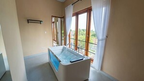 Une salle de bain moderne avec une baignoire sur pieds, un miroir et un balcon agrémenté de rideaux.