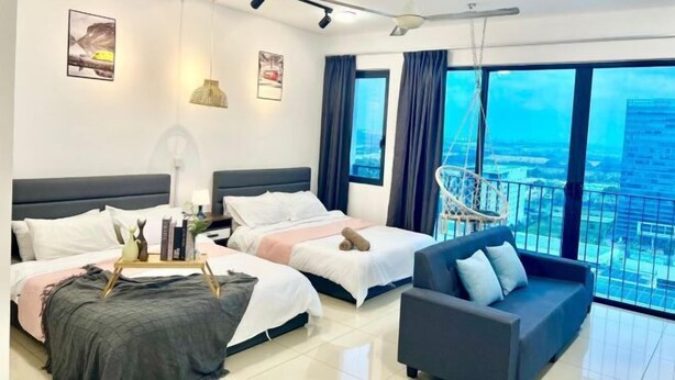 Een moderne hotelkamer met twee bedden, een bank en een balkon met uitzicht op de stad.