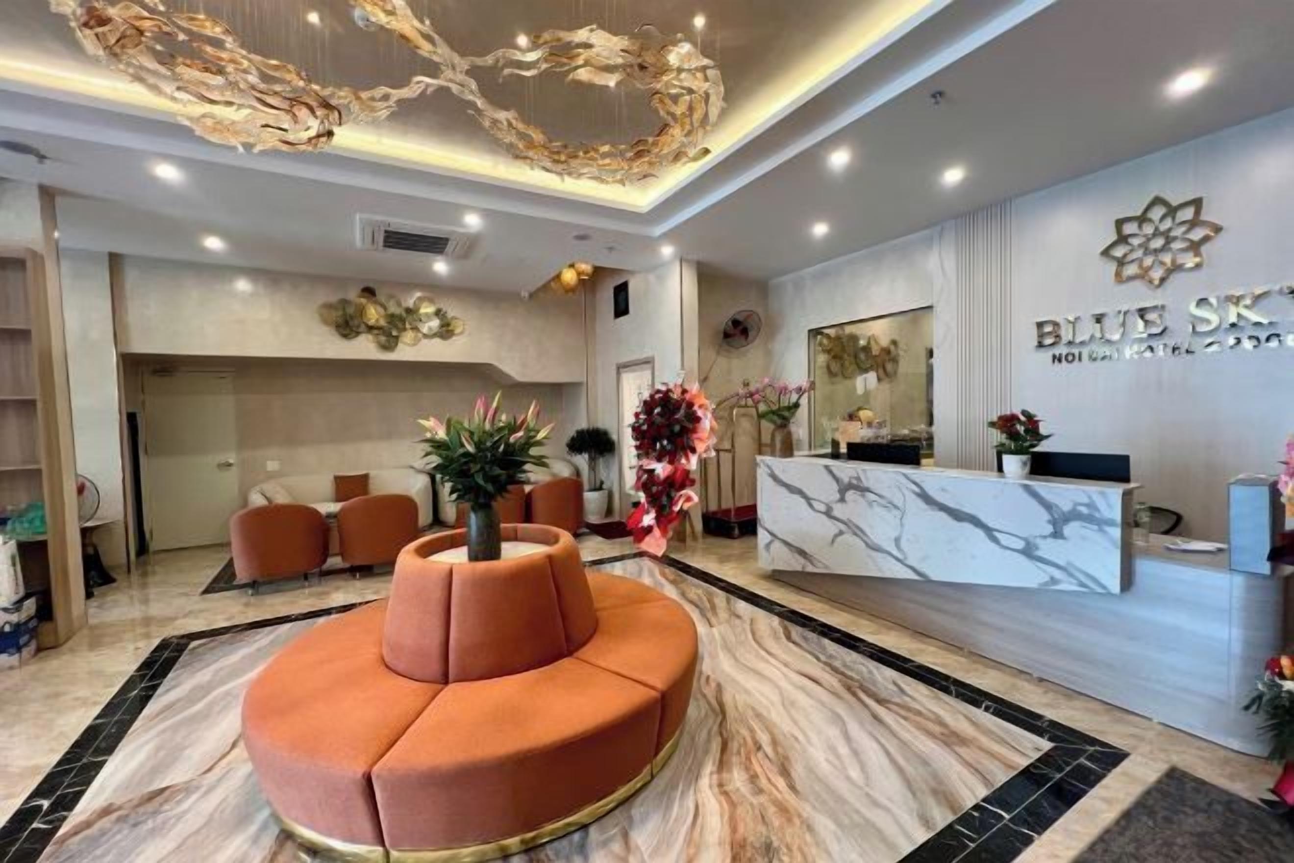 A hotel reception area with a marble reception desk, a central seating area, and a decorative ceiling.