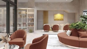 A modern living room with a sofa, chairs, a coffee table, and a bookshelf.