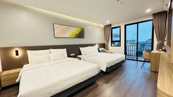 A hotel room with two beds, a desk, a chair, and a large window with a view of the airport.