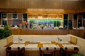 Een restaurant met een bar, zitplaatsen met menu's en een toonbank met drankjes en gerechten.