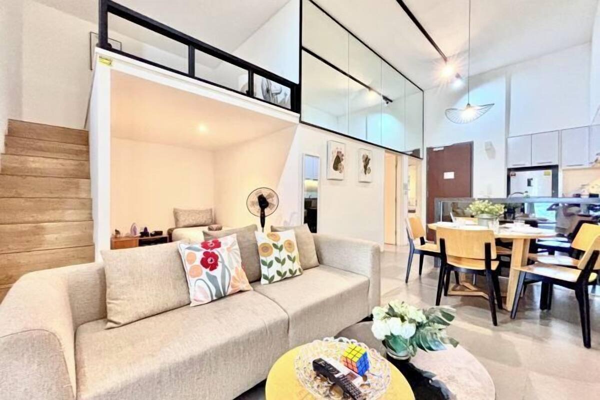 Una sala de estar moderna con un sofá, una mesa de centro y un comedor con sillas y una mesa.