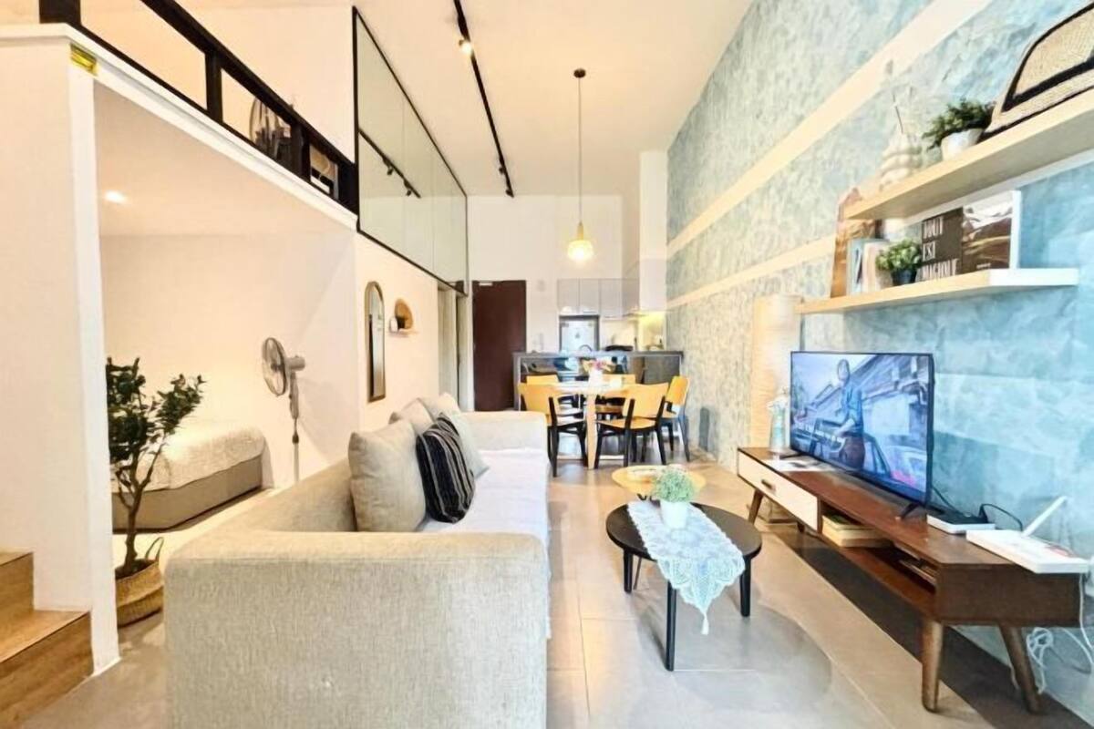 Una sala de estar moderna con un sofá, una mesa de centro, un televisor y un comedor con sillas y una mesa.