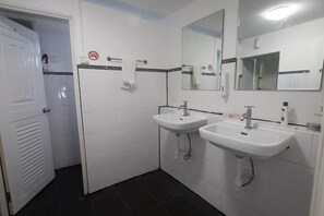 A bathroom with two sinks, a mirror, and a door. - Bodega Soi 23 Bangkok (Bangkok)