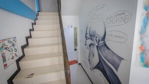 Un escalier orné d’une fresque murale représentant le visage d’un homme et des bulles de dialogue.