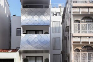 A multi-story building with balconies, large windows, and a modern architectural design. - Express by M Village Vo Van Kiet, a brand of Modern Village Lifestyle (Ho Chi Minh City)