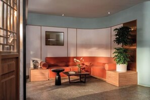 A modern living room with a sectional sofa, a coffee table, and a potted plant. - Express by M Village Vo Van Kiet, a brand of Modern Village Lifestyle (Ho Chi Minh City)