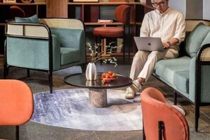 Una sala de estar moderna con un sofá, sillones, una mesa de centro y una computadora portátil.