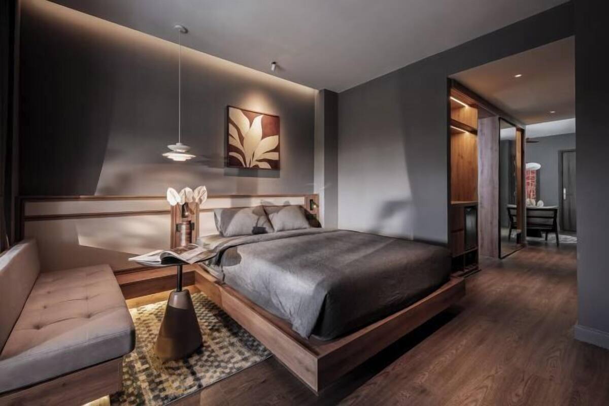 A modern bedroom with a large bed, bedside tables, and a built-in wardrobe.