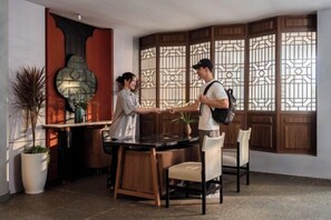 Habitación de hotel con un separador de estilo asiático tradicional, una mesa de comedor y sillas.