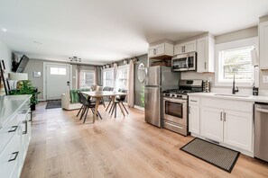 Una cocina moderna con comedor, electrodomésticos de acero inoxidable y vistas al exterior.