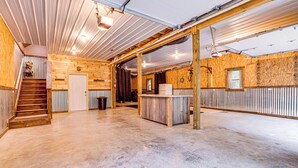 A spacious, well-lit interior with a wooden staircase, a reception desk, and a large open area. - Hot Tub Haven 10 Mi to Hocking Hills (Amanda)