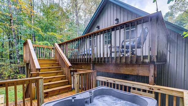 A wooden deck with a hot tub, a staircase, and a view of a car parked outside. - Hot Tub Haven 10 Mi to Hocking Hills (Amanda)