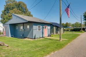 A small, single-story building with a blue exterior and a red door, located on a grassy area beside a road. - 'Blue Heron' Walk to Kelso Beach! Pet-Friendly Gem (Erie)