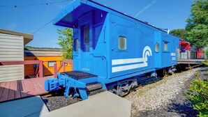 A blue train caboose with a small platform, a window, and a door. - ‘Choo Choo Blue,’ Converted Railcar in DuBois! (DuBois)