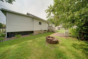 A residential property with a well-maintained lawn, a brick fire pit, and a wooden deck. - 'Wishin & Fishin' Walkable Erie Home By the Beach! (Erie)