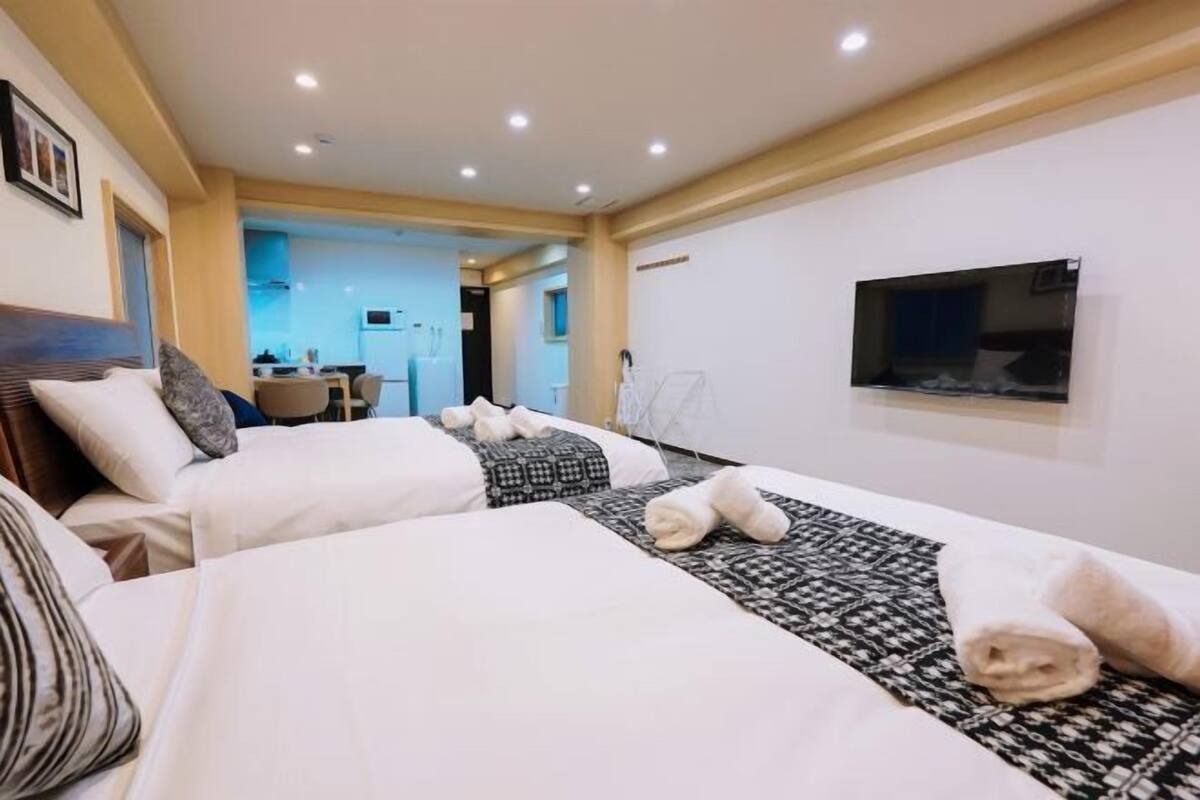 Une chambre d  ’hôtel avec deux lits, une télévision et un bureau avec une chaise.