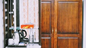 A kitchenette with a coffee maker, cups, and a refrigerator. - Gokul Jawai (Bali)