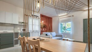Et moderne køkken med hvide skabe, et træspisebord og en hængende lampe.