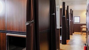 Un couloir d’hôtel avec des lambris en bois et des portes de chambres numérotées.