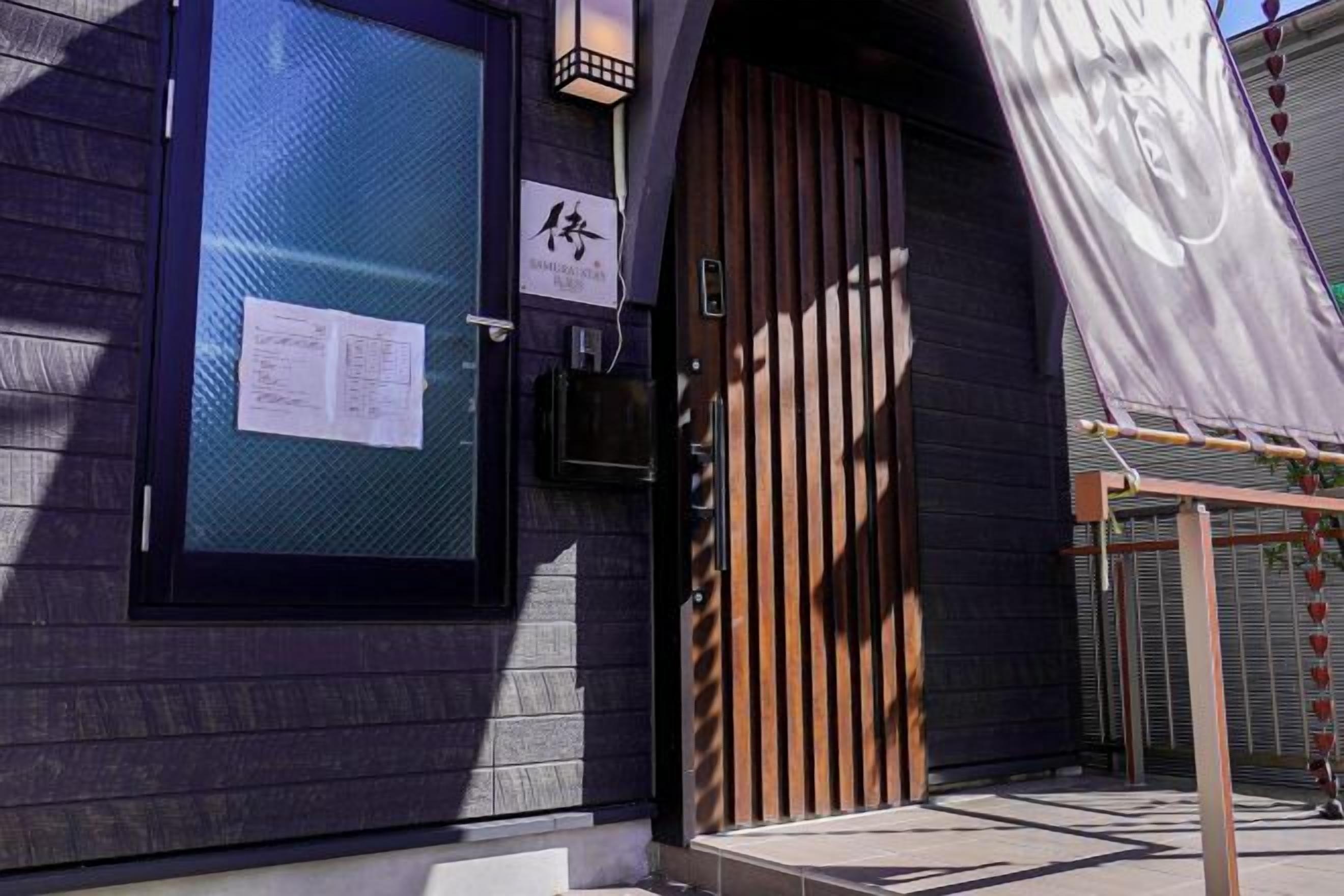 A building entrance with a wooden door and a metal gate.