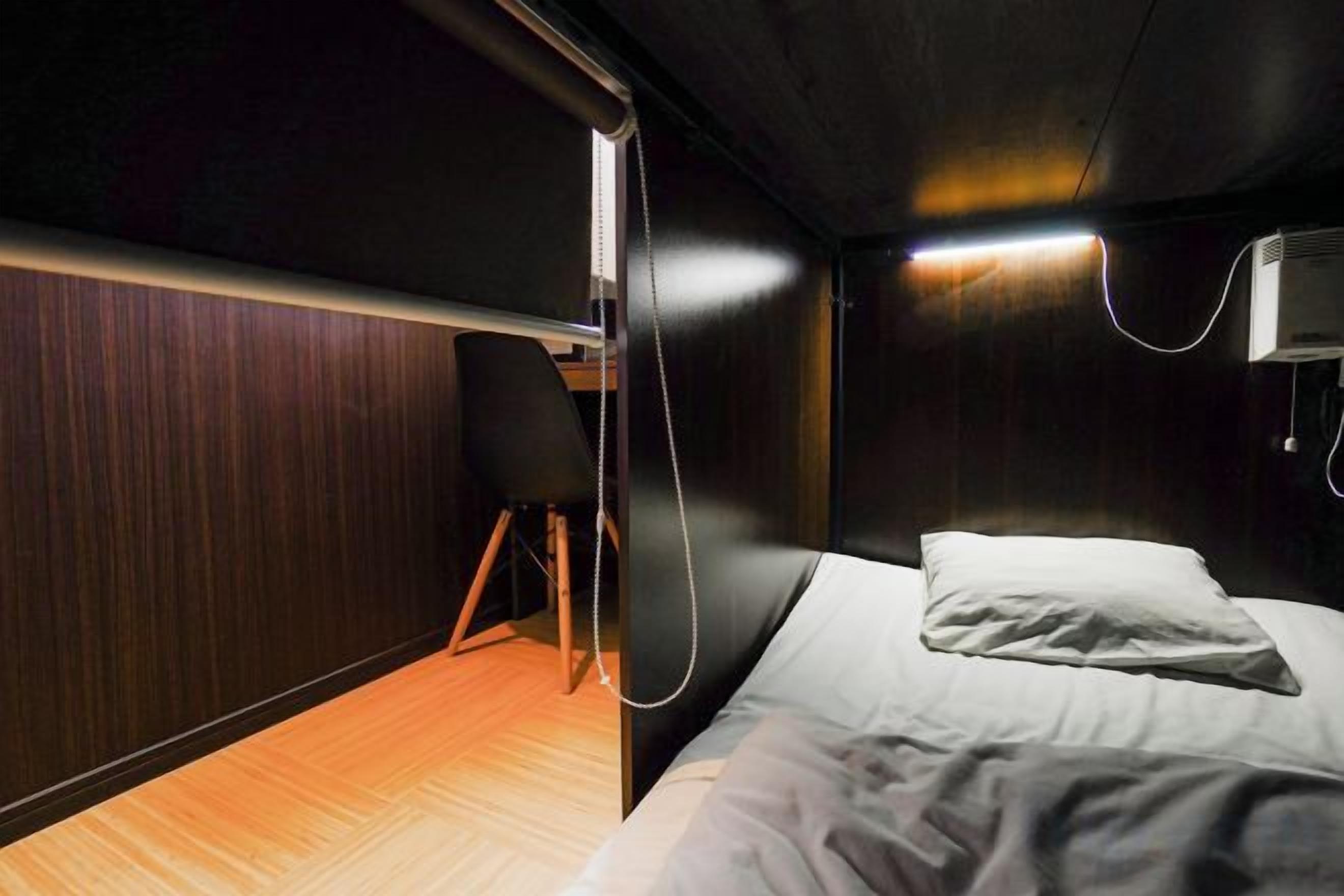 A compact room with a bed, a chair, and a desk.