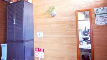 A wooden wall with a cabinet, a mirror, and a sign.