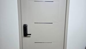 A white door with a black handle and two horizontal slots. - EDEN GUEST HOUSE (Seoul)