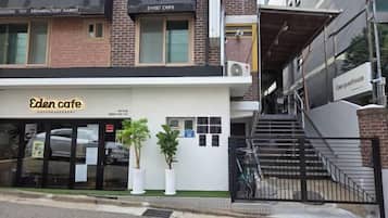 Um edifício com fachada e escadaria que leva a um andar superior.