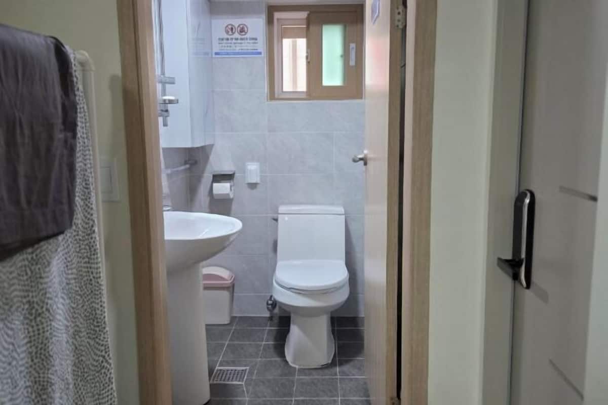 A bathroom with a toilet, sink, and a towel rack.