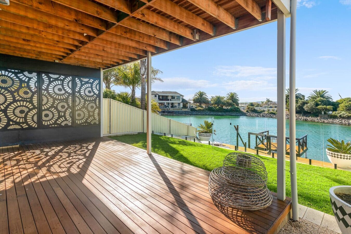 A wooden deck with a view of a river and houses in the background.