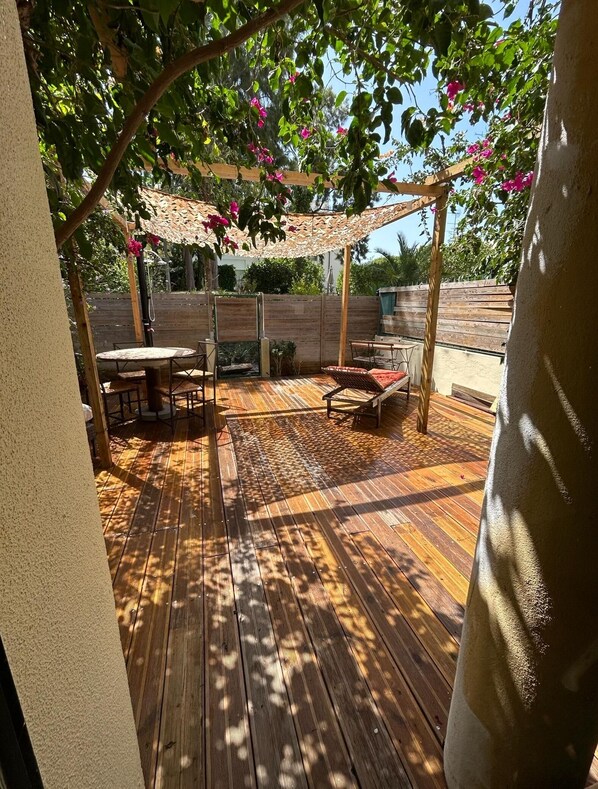A wooden deck with outdoor furniture, including a table and chairs.