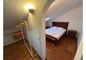 Ein Schlafzimmer mit Bett, Nachttisch und einer Pendelleuchte.