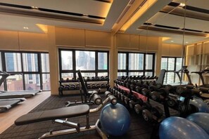 A gym with exercise equipment, treadmills, and dumbbells. - Agile Bukit Bintang TRX Pavilion by FaceHome (Kuala Lumpur)