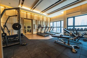 Ein Fitnessstudio mit Laufbändern, Kurzhanteln und Krafttrainingsgeräten.