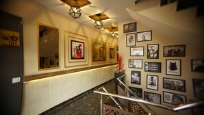 A hotel lobby with a marble staircase, framed artwork on the walls, and a modern ceiling design. - HOTEL SOLUXE (Jagadhri)