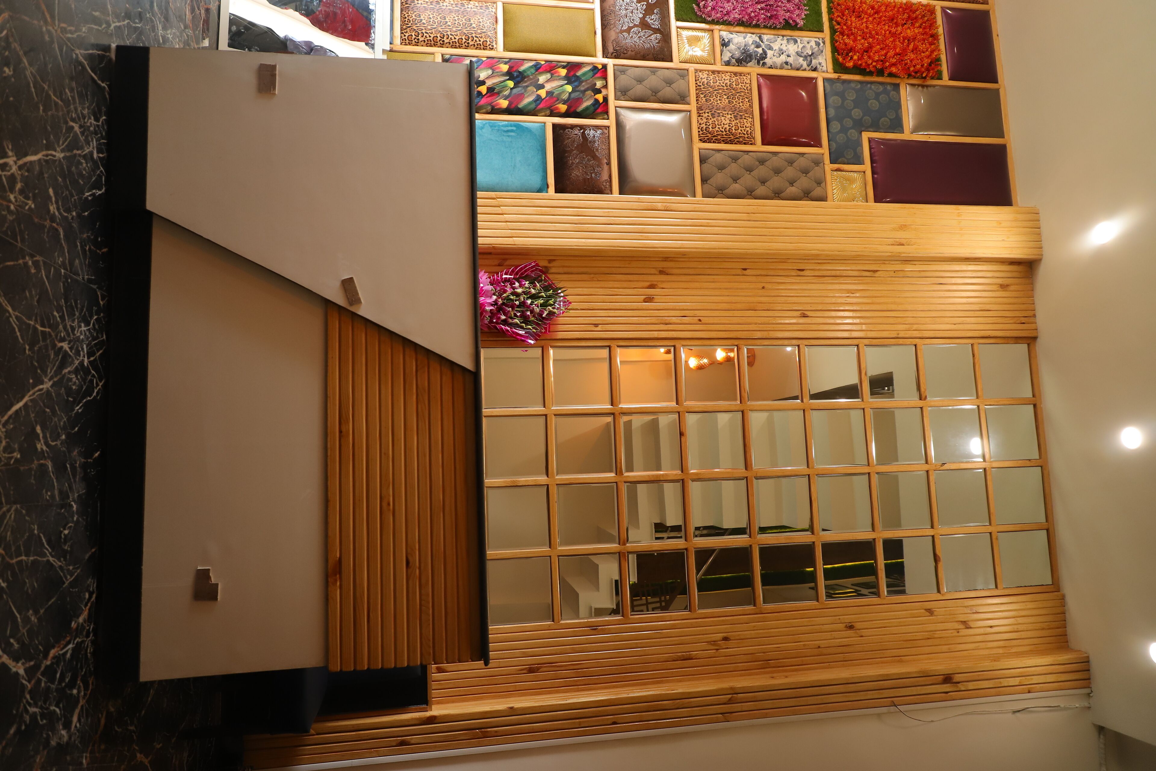 Un interior moderno con un banco de madera, un panel de vidrio y varios paneles de colores en la pared.