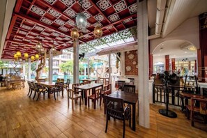 An indoor dining area with wooden flooring, tables, chairs, and hanging pendant lights. - Lanna Hotel by Kasalong Resort and Spa Pattaya (Pattaya)