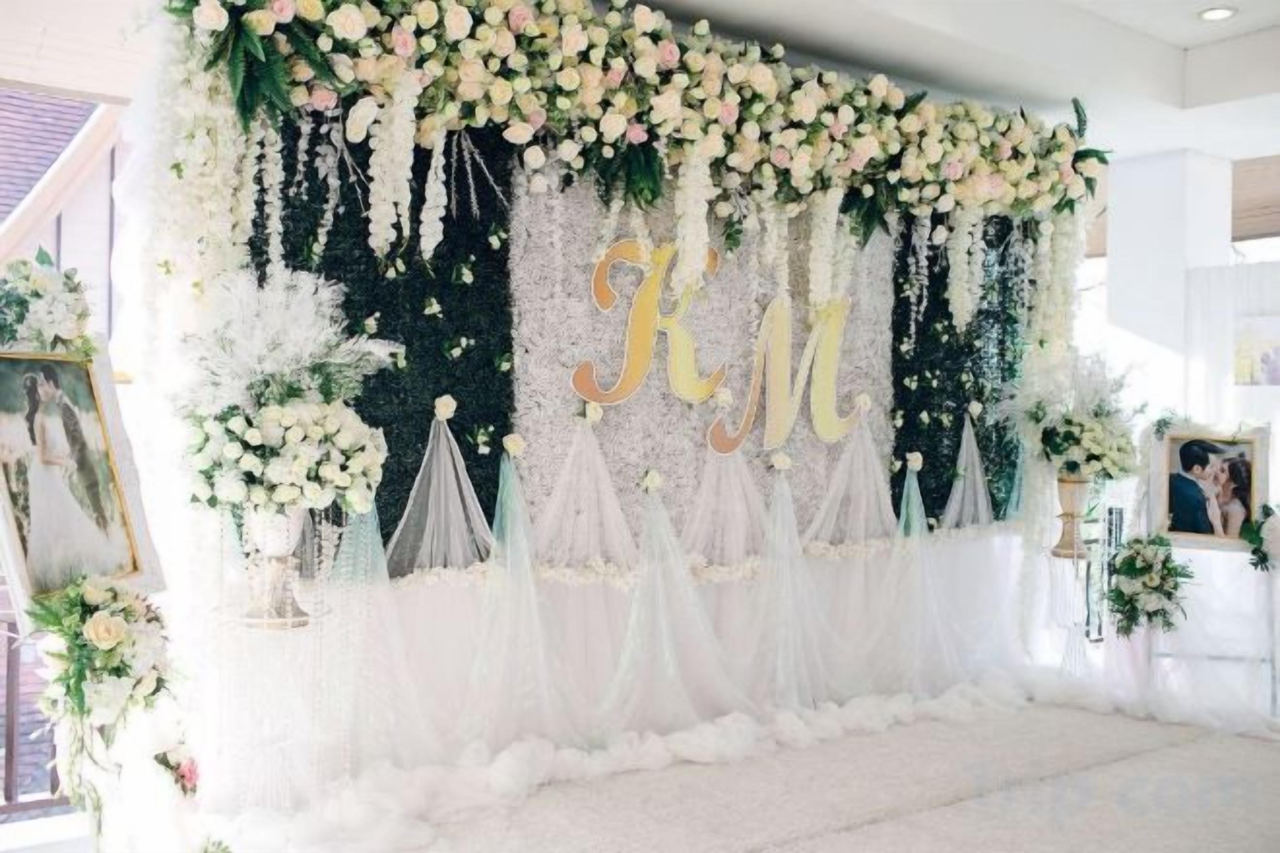 A wedding stage with floral decorations and a backdrop.