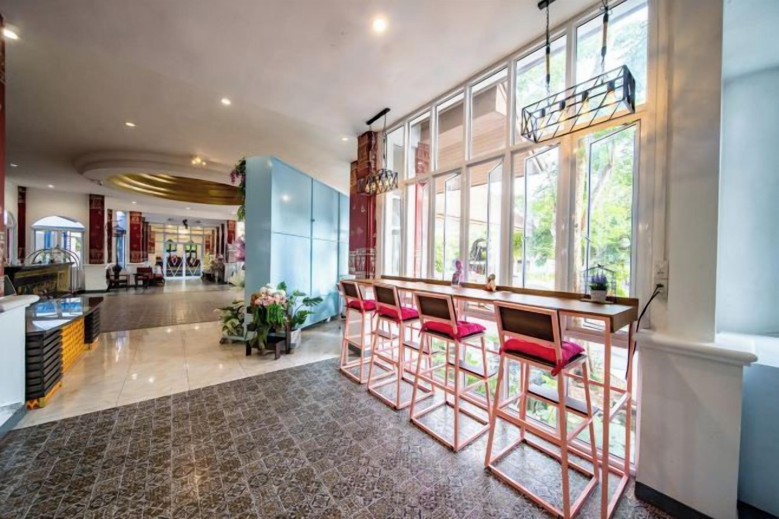 Eine großzügige Lobby mit Barbereich, Sitzgelegenheiten und Blick durch große Fenster.