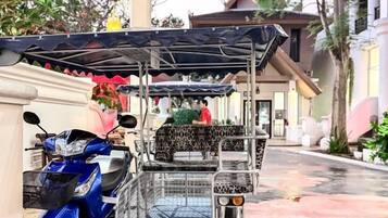 A covered parking area with a blue scooter and a covered cart.