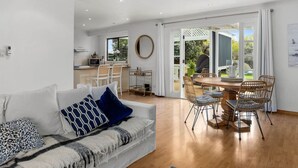Un salon moderne comprenant un canapé, un coin repas et une cuisine.