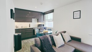 Eine moderne Wohnung mit Wohnbereich, inklusive Sofa und Esstisch.