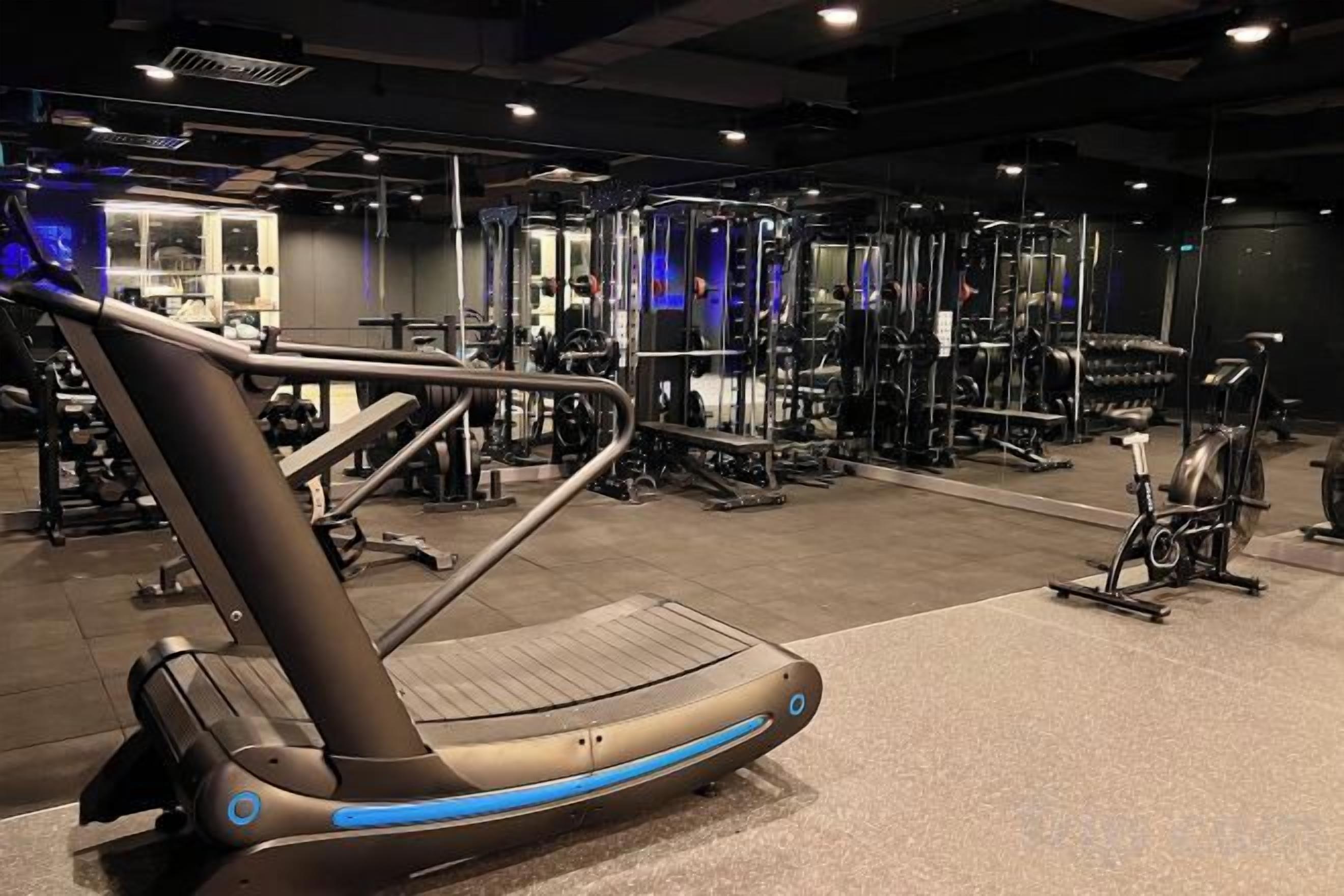 Una palestra con attrezzature per esercizi, tra cui tapis roulant e macchinari per pesi.