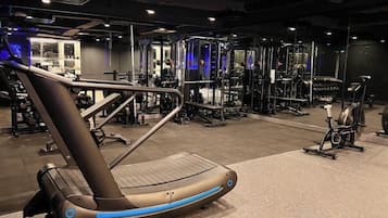 Una palestra con attrezzature per esercizi, tra cui tapis roulant e macchinari per pesi.