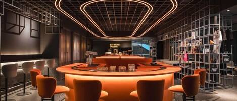 A modern bar area with a curved counter, bar stools, and a neon light ceiling.