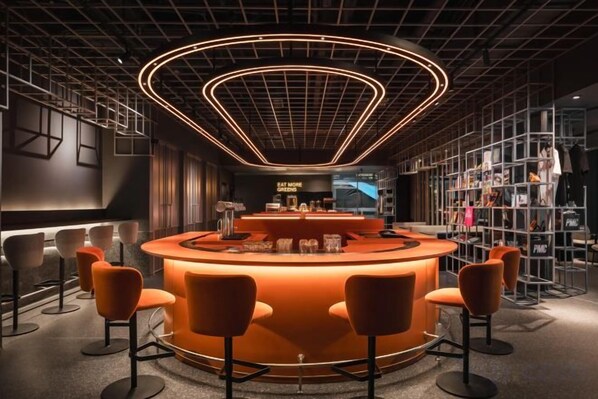 A modern bar area with a curved counter, bar stools, and a neon light ceiling. - CapsuleTransit MAX - Terminal 2 (Sepang)